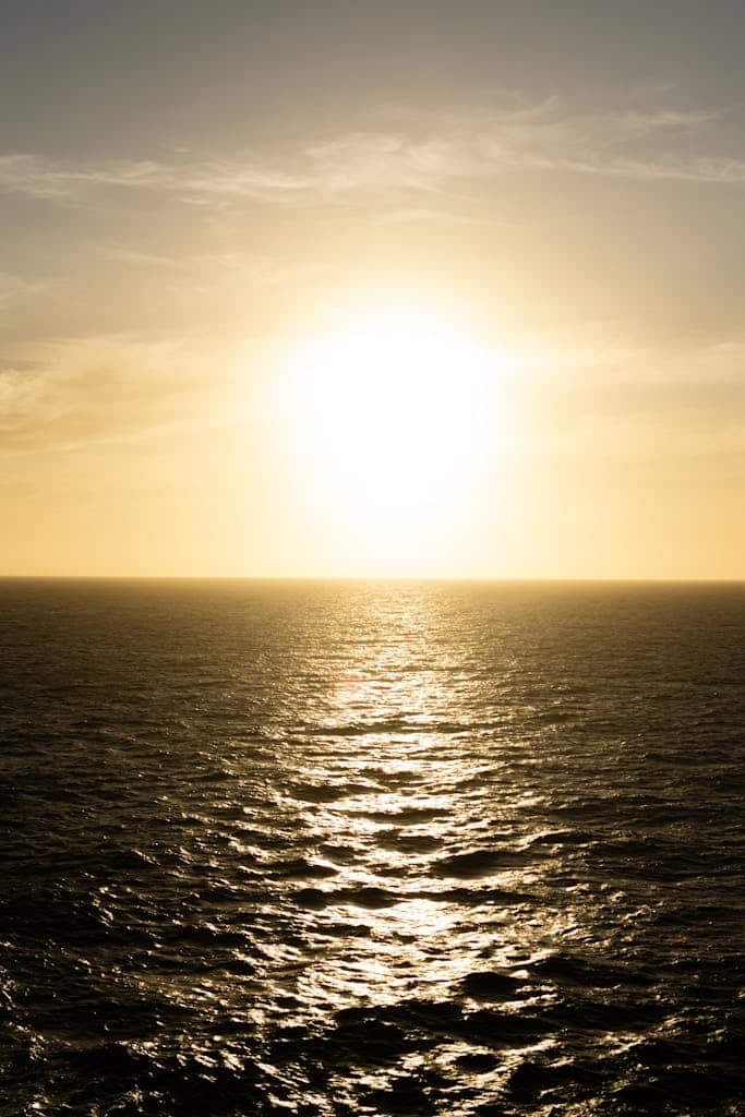 Captivating sunset casting golden hues over a vast and tranquil ocean horizon.
